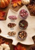 Three jars of fall-themed chunky glitter — Blushing Pumpkin, Falling Leaves, and Autumn Pumpkin — with pumpkin confetti on a leaf-shaped dish
