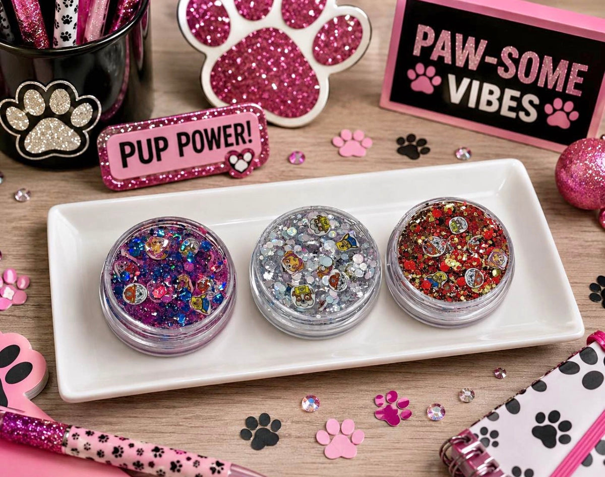 Three jars of Paw Patrol-themed hair glitter in pink, silver, and red-gold with paw print confetti