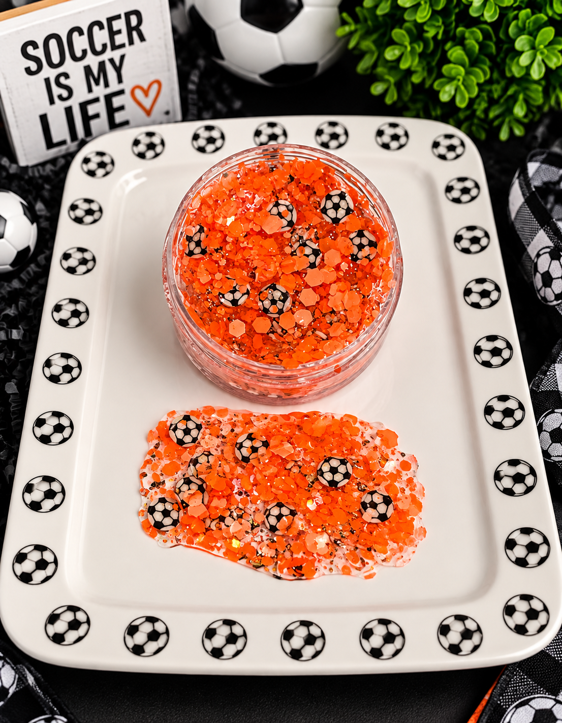 Orange chunky glitter with tiny soccer ball confetti in a jar on a soccer-themed tray