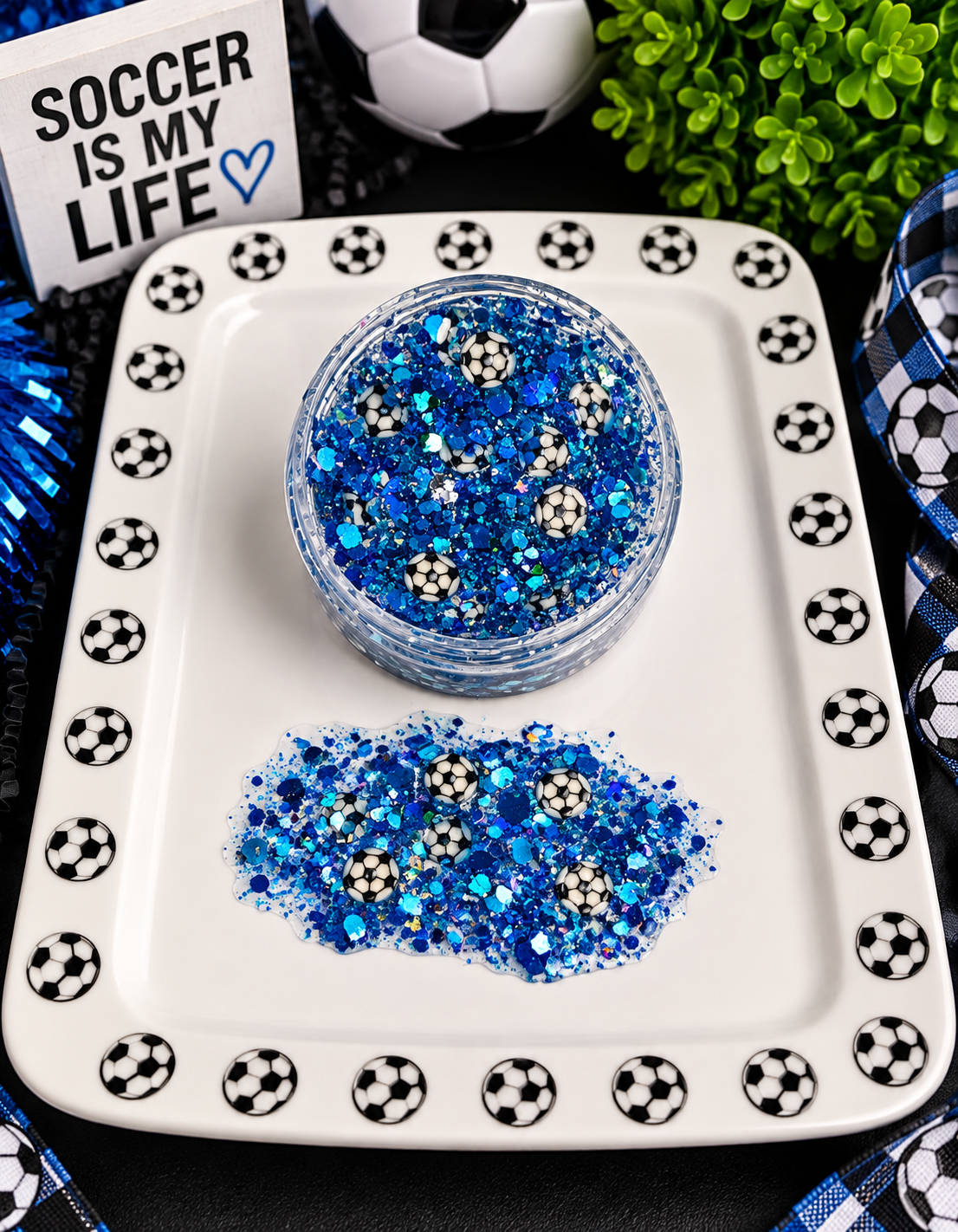 Blue chunky glitter with tiny soccer ball confetti in a jar on a soccer-themed tray